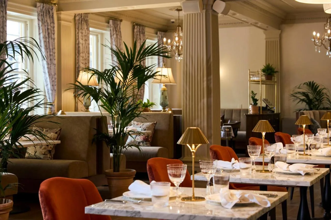 a restaurant with tables and chairs and plants at Francis Hotel Bath in Bath